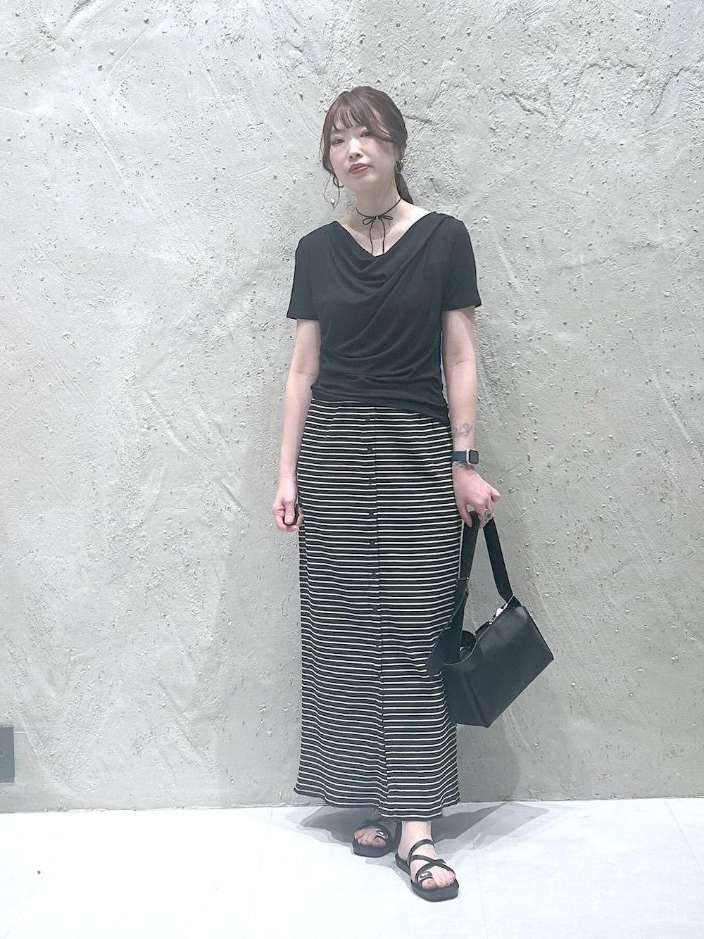 ブラック系のサンダル、ブラック系のTシャツ/カットソー、ブラック系のショルダーバッグを着用したレディースの夏コーディネートの1枚目の写真