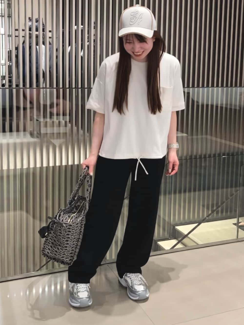 ブラック系のTシャツ/カットソー、ブラック系のその他パンツ、シルバー系のスニーカーを着用したレディースの春コーディネートの1枚目の写真