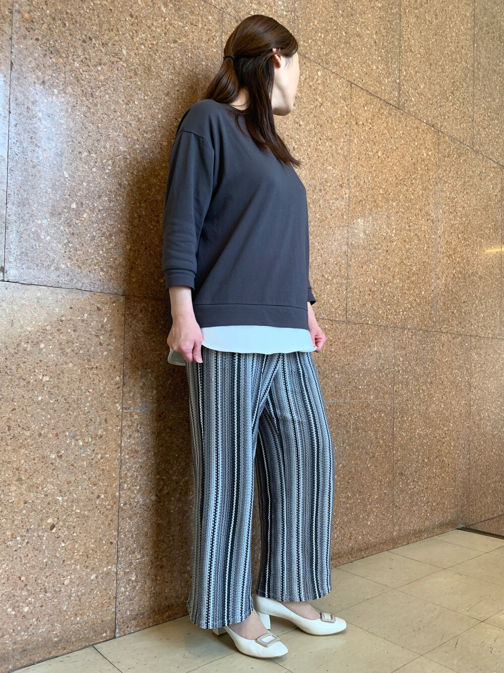 ホワイト系のパンプスを着用したレディースの春コーディネートの1枚目の写真