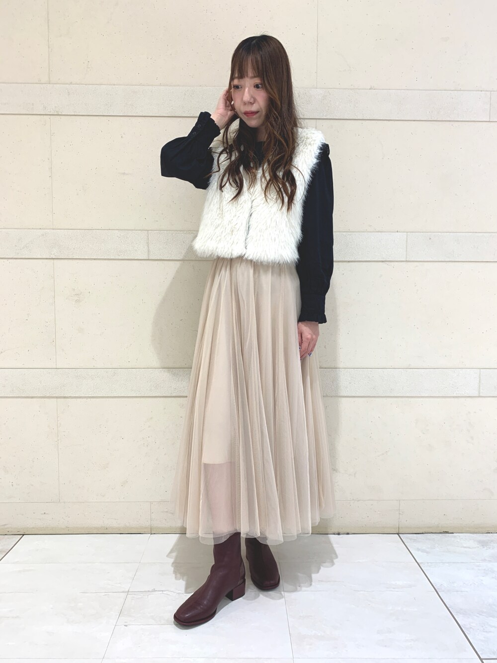 レッド系のブーツを着用したレディースの秋コーディネートの1枚目の写真