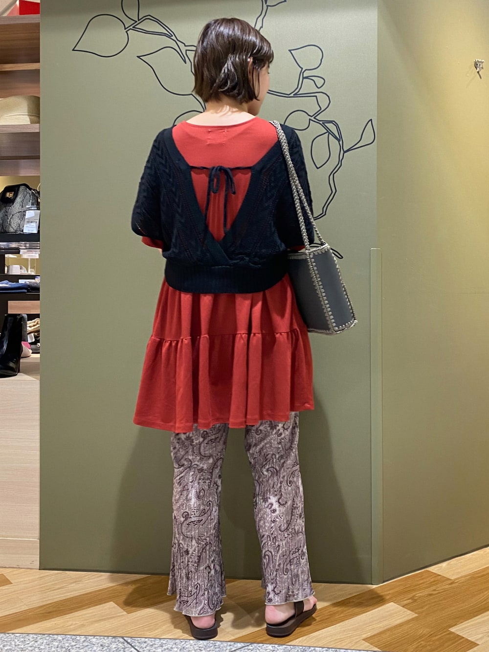 ブラック系のベスト、レッド系のTシャツ/カットソー、ブラウン系のその他パンツを着用したレディースの秋コーディネートの1枚目の写真