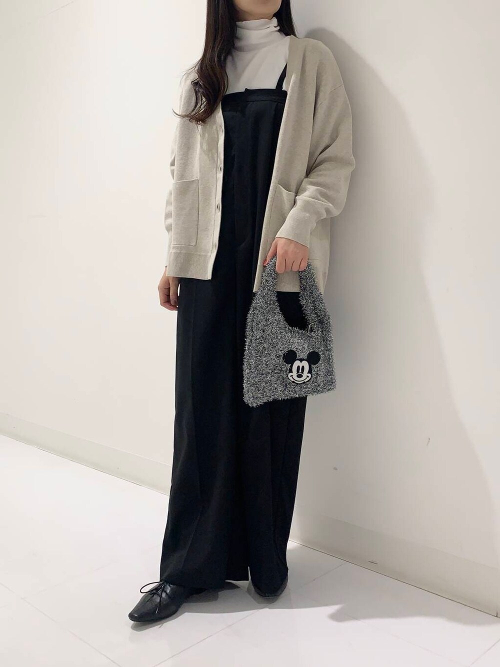 ブラック系のその他シューズ、ベージュ系のカーディガン/ボレロ、ホワイト系のTシャツ/カットソーを着用したレディースの秋コーディネートの1枚目の写真