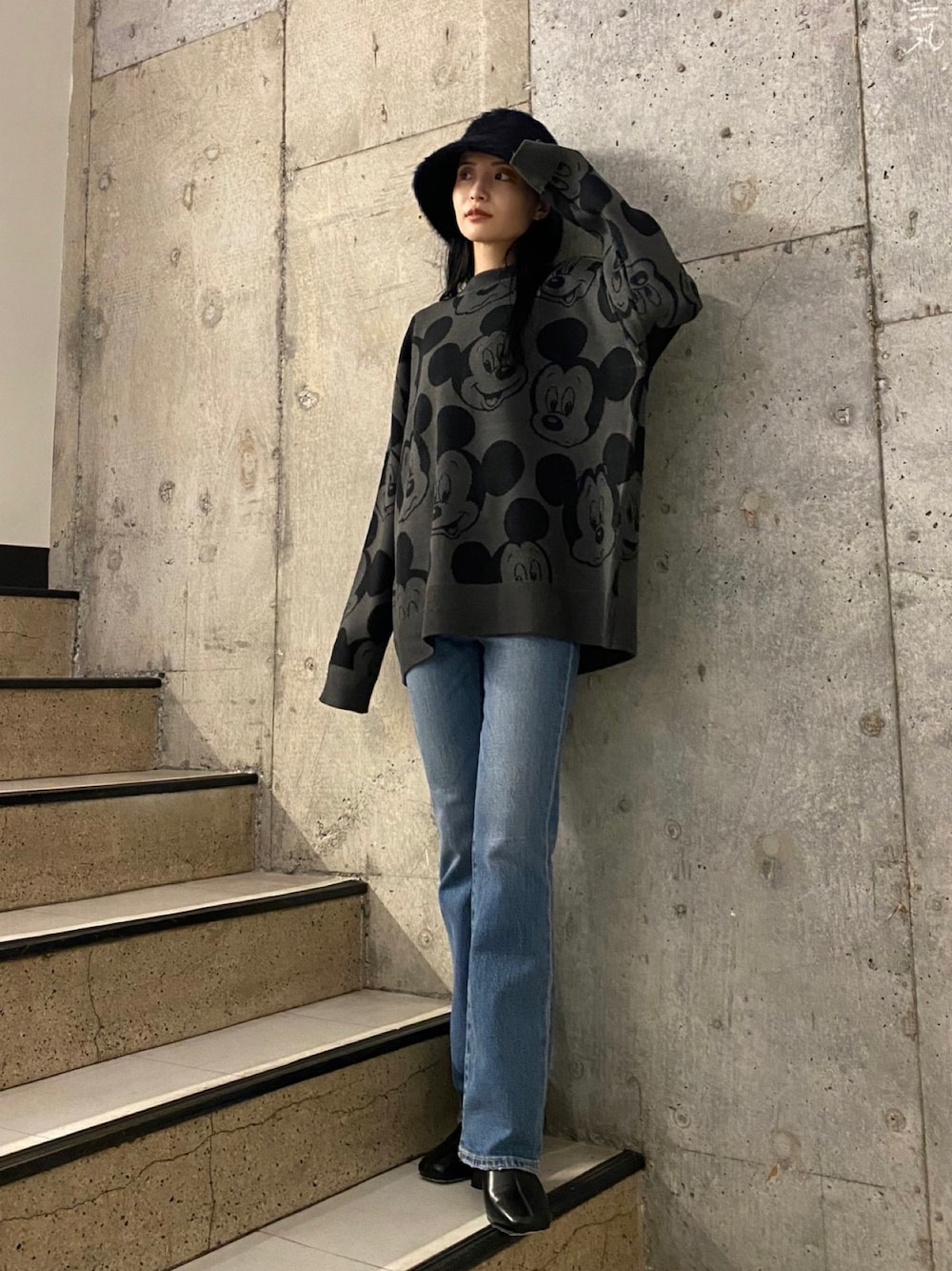 ブルー系のデニムパンツ、ブラック系のブーツ、グレー系のニット/セーターを着用したレディースの秋コーディネートの1枚目の写真