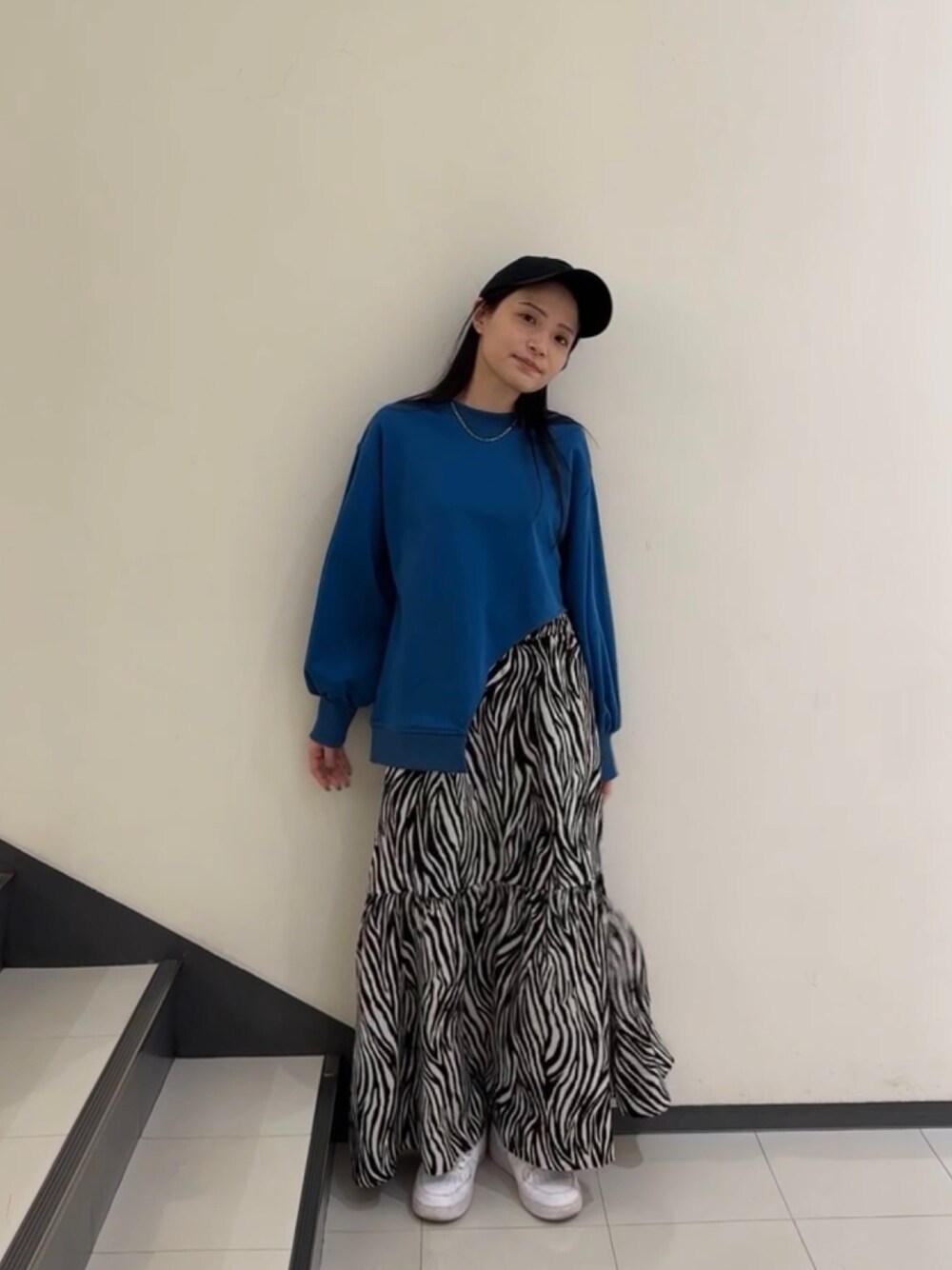 ブルー系のTシャツ/カットソー、ホワイト系のスカート、ブラック系のキャップを着用したレディースの春コーディネートの1枚目の写真