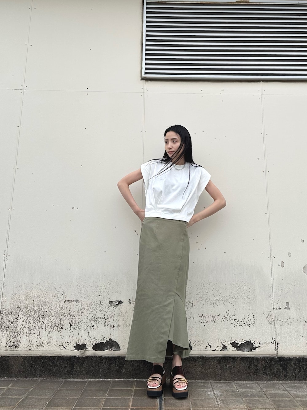 ホワイト系のTシャツ/カットソー、グリーン系のスカート、その他のサンダルを着用したレディースの春コーディネートの1枚目の写真