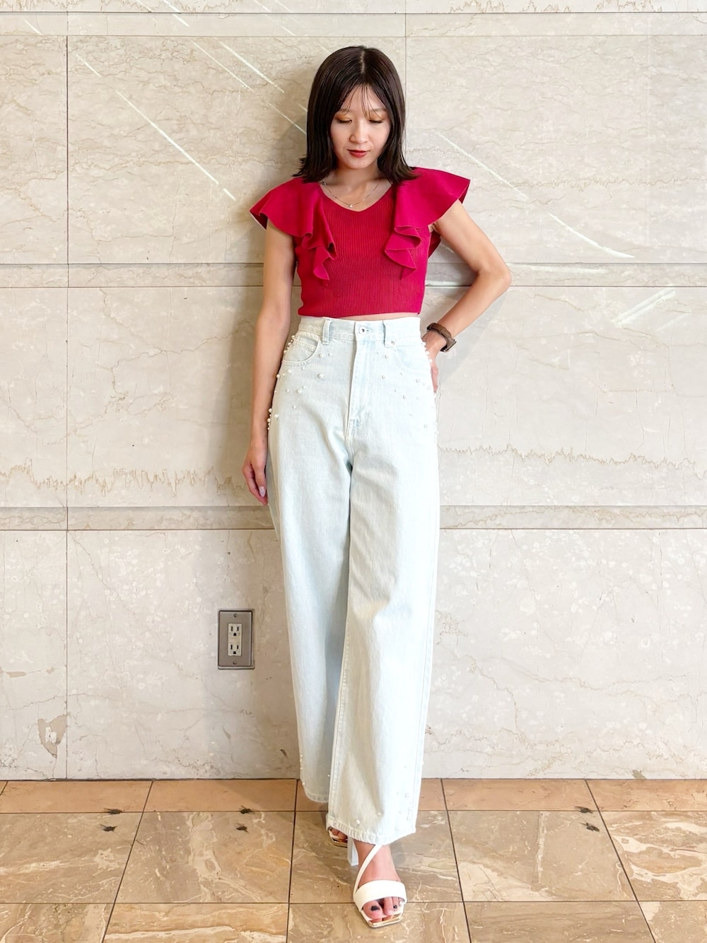 ブルー系のデニムパンツ、ホワイト系のサンダル、レッド系のニット/セーターを着用したレディースの夏コーディネートの1枚目の写真