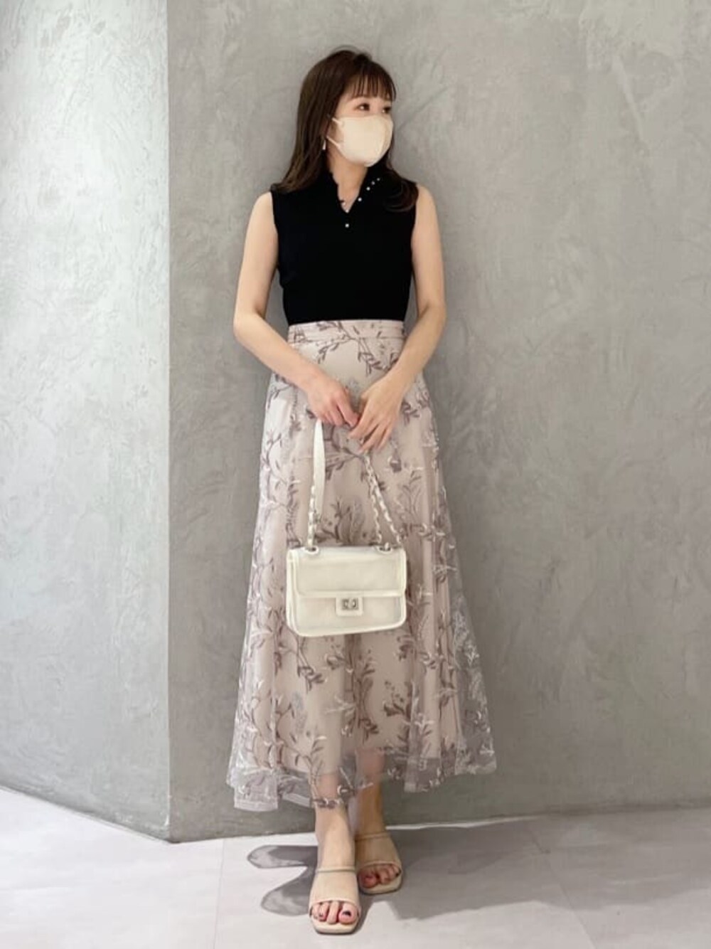 ホワイト系のショルダーバッグ、ブラック系のニット/セーター、ピンク系のスカートを着用したレディースの春コーディネートの1枚目の写真