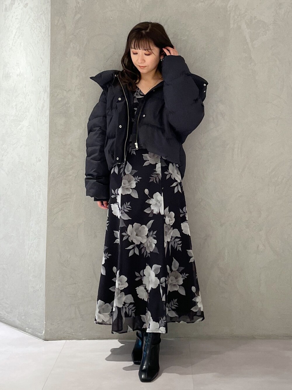 ブラック系のワンピース、ブラック系のダウンジャケット/コート、ブラック系のブーツを着用したレディースの冬コーディネートの1枚目の写真