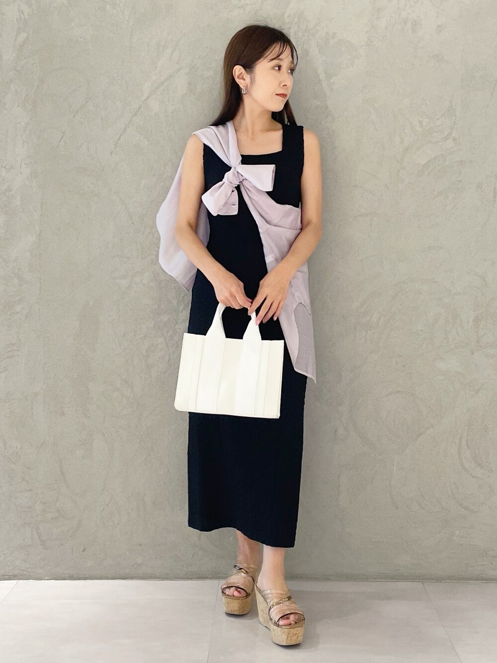 ピンク系のトートバッグ、ブラウン系のサンダル、ブラック系のワンピースを着用したレディースの夏コーディネートの1枚目の写真