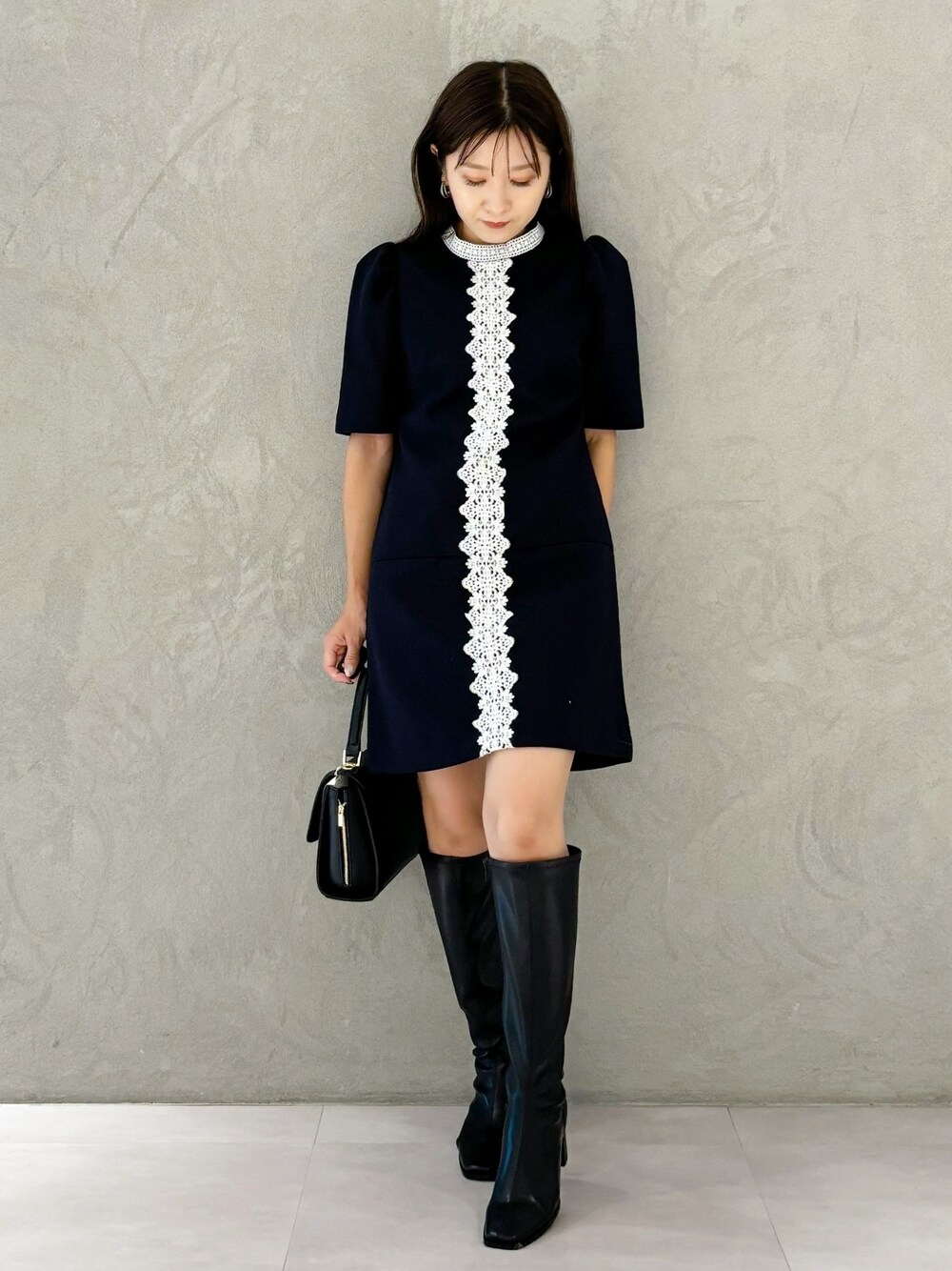 ブルー系のワンピース、ブラック系のブーツ、ブラック系のショルダーバッグを着用したレディースの秋コーディネートの1枚目の写真