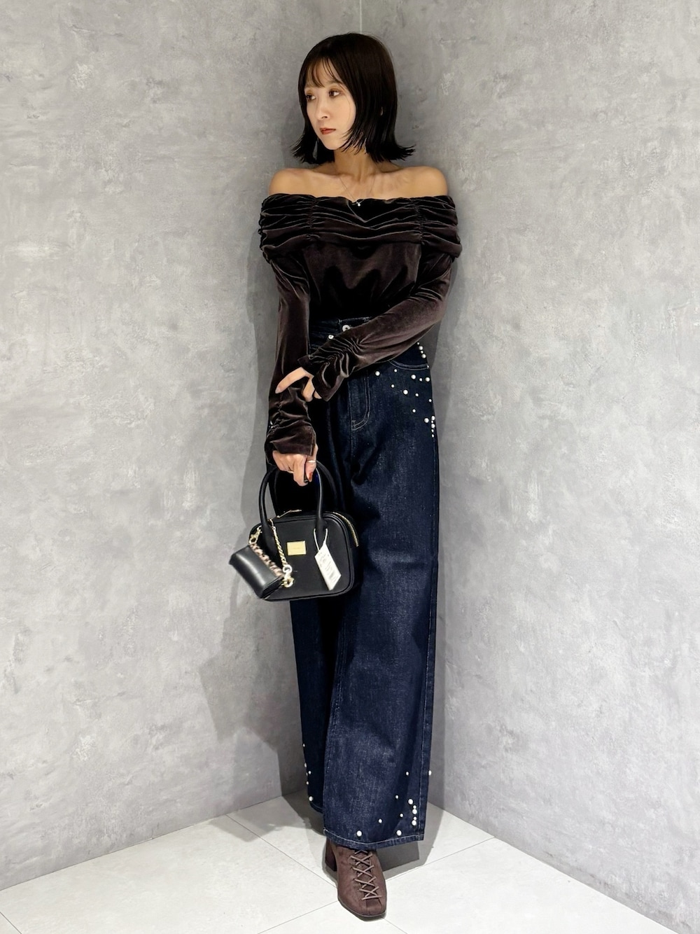 ブルー系のデニムパンツ、ブラウン系のTシャツ/カットソー、ブラウン系のブーツを着用したレディースの秋コーディネートの1枚目の写真