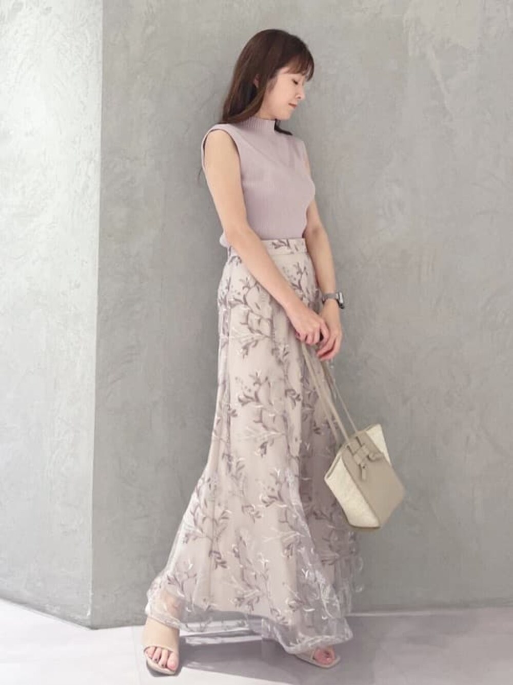 ベージュ系のトートバッグ、ピンク系のスカート、ベージュ系のサンダルを着用したレディースの夏コーディネートの1枚目の写真