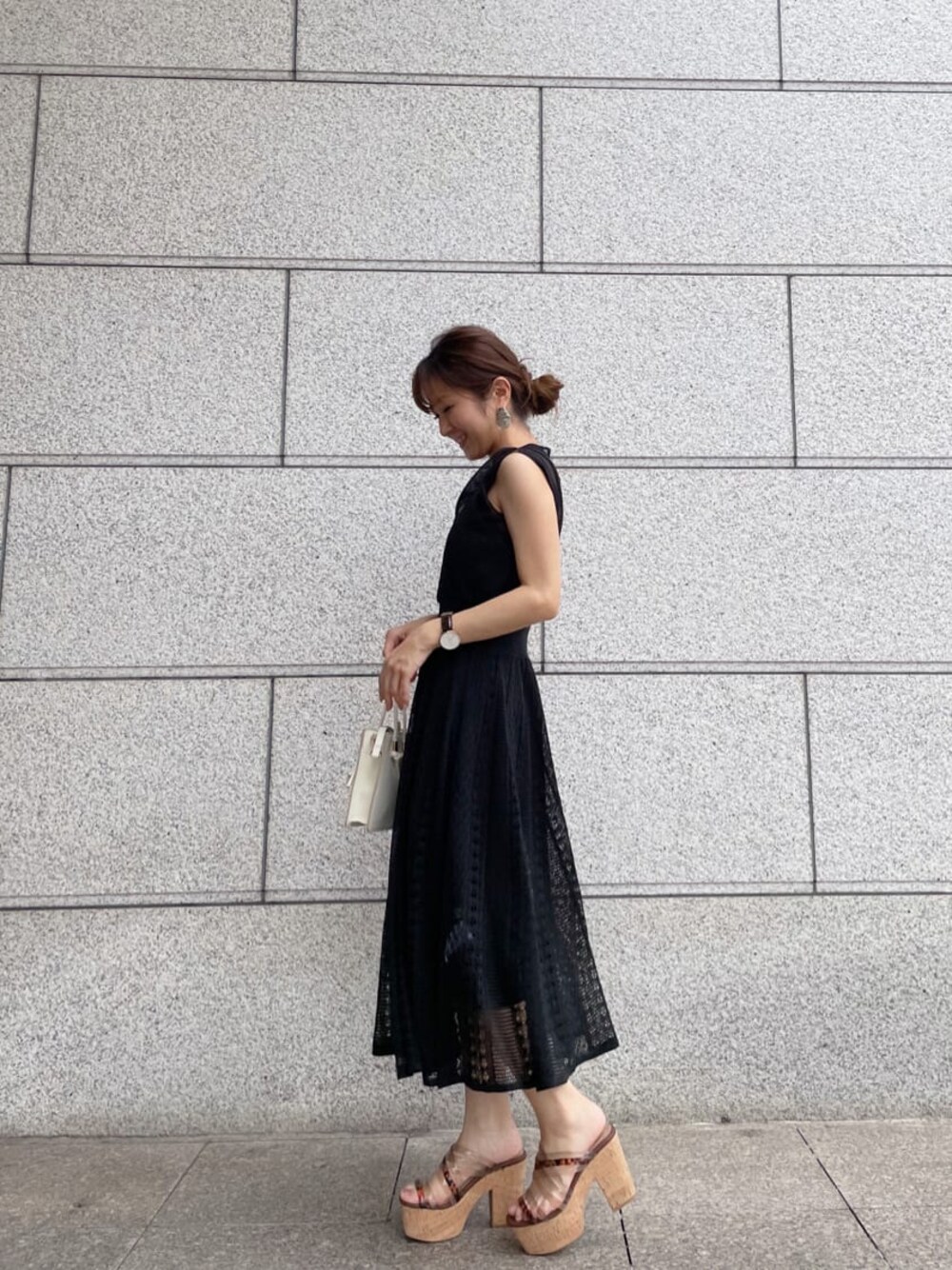 ベージュ系のサンダル、ブラック系のワンピースを着用したレディースの夏コーディネートの1枚目の写真