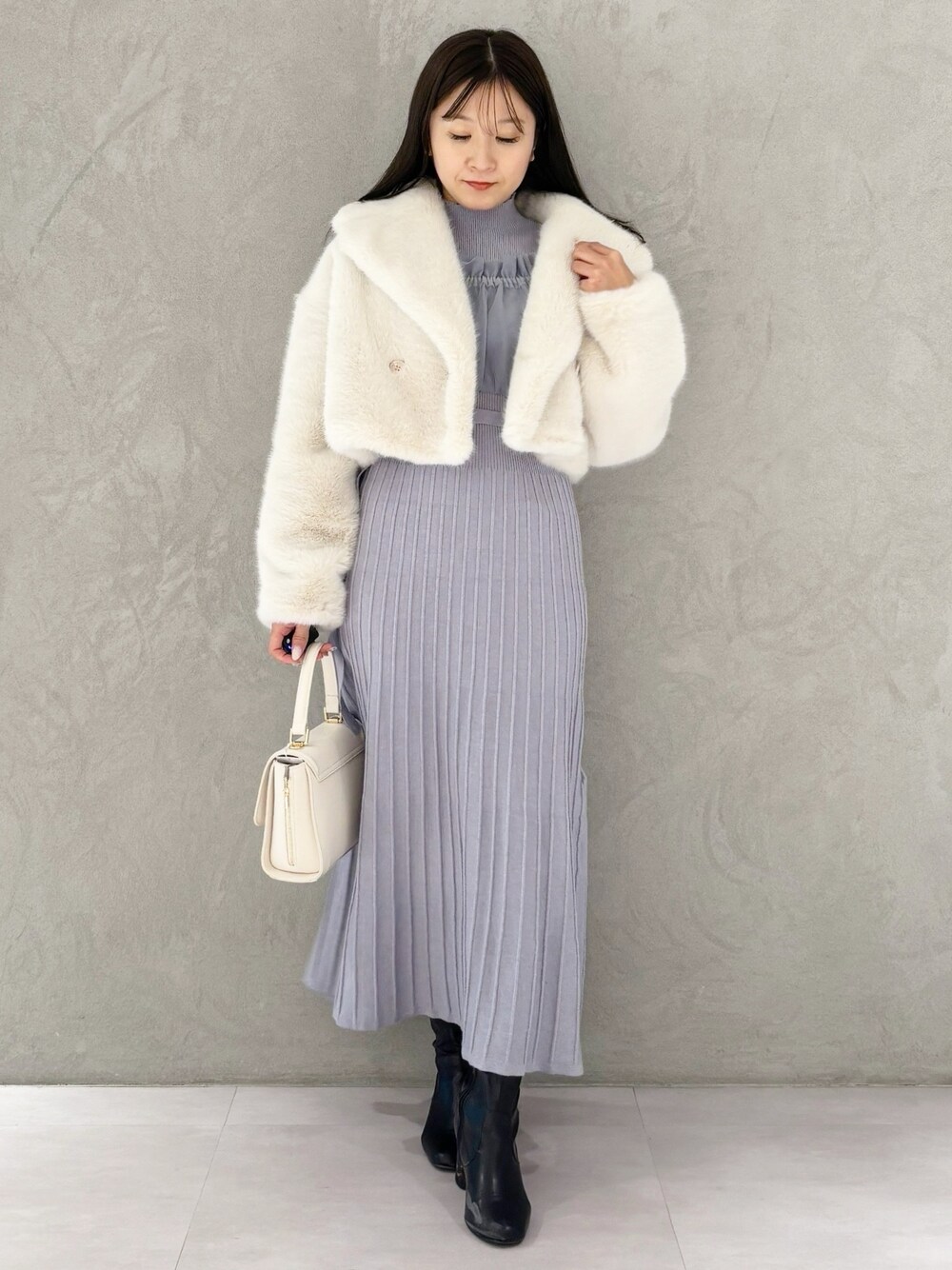 ブルー系のワンピース、ブラック系のブーツ、ホワイト系のその他アウターを着用したレディースの冬コーディネートの1枚目の写真