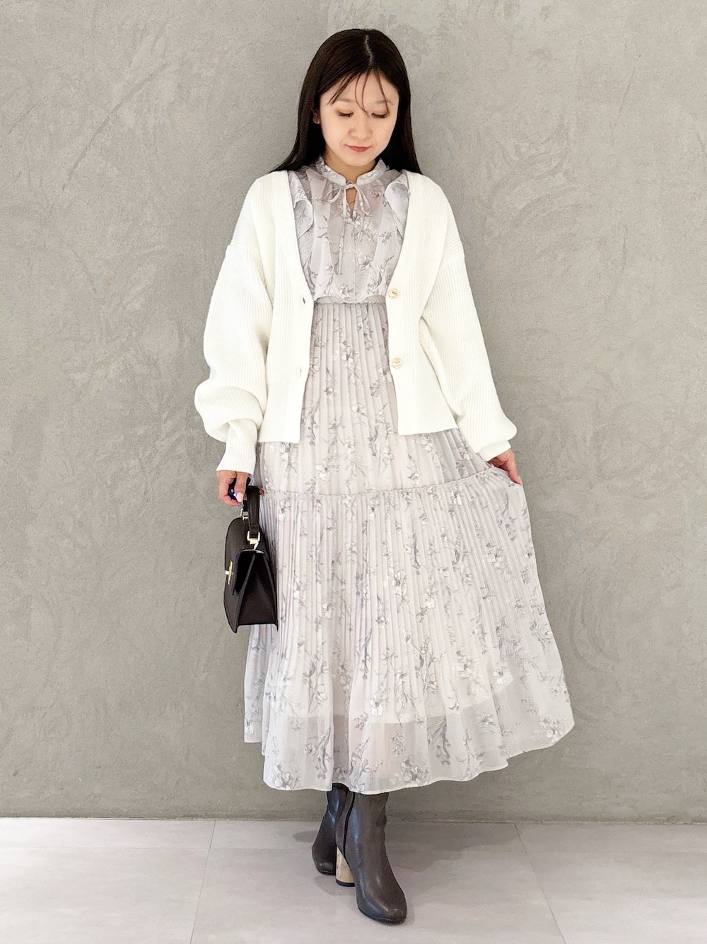 ピンク系のワンピース、ブラウン系のブーツ、ブラウン系のハンドバッグを着用したレディースの冬コーディネートの1枚目の写真