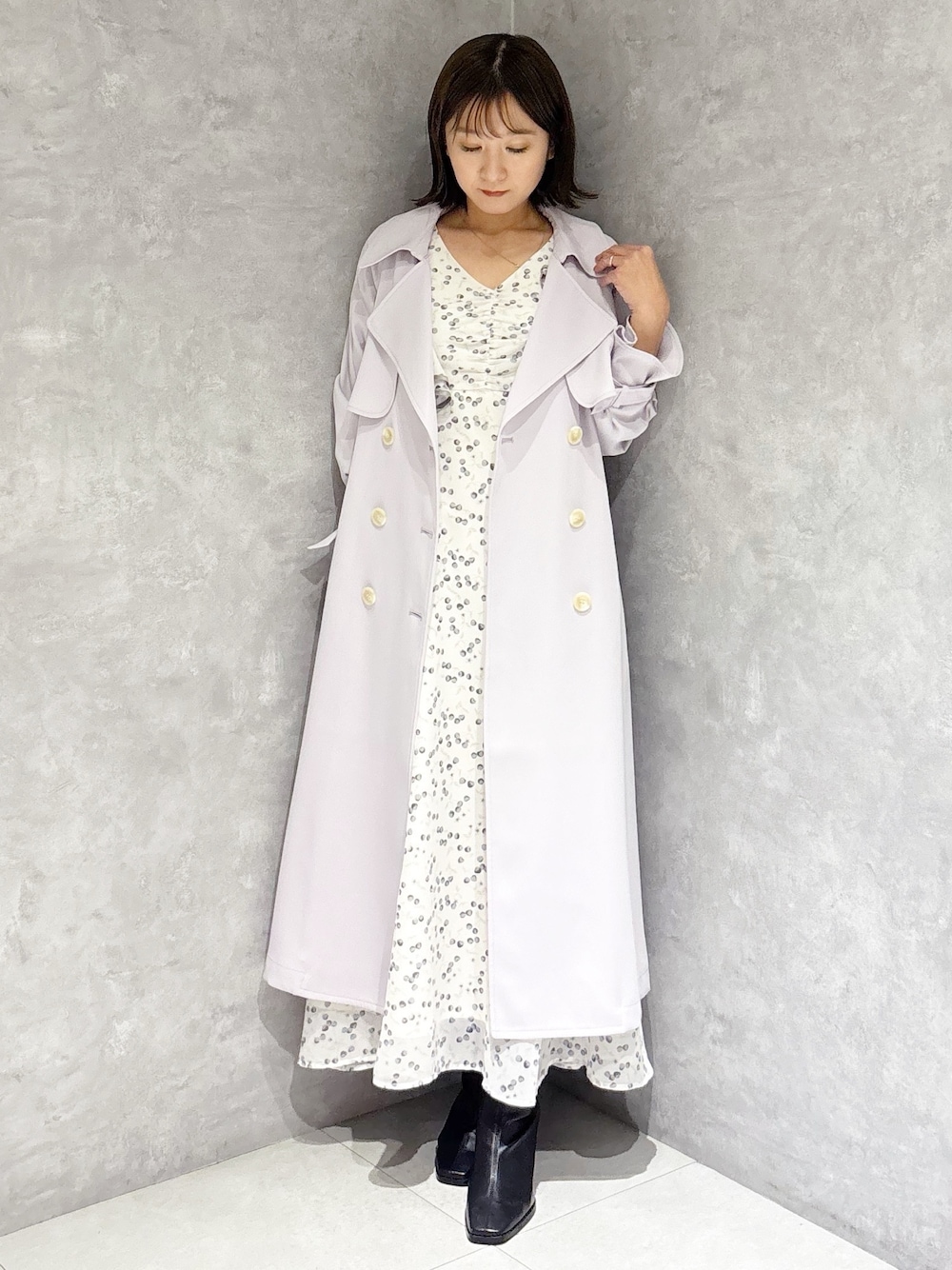 ホワイト系のワンピース、ブラック系のブーツ、パープル系のトレンチコートを着用したレディースの冬コーディネートの1枚目の写真