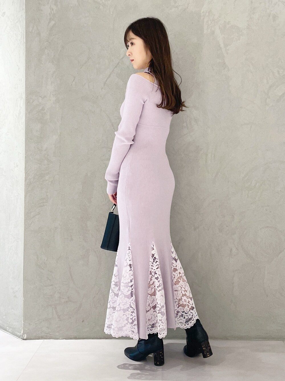 ピンク系のワンピース、ブラック系のブーツ、ブラック系のハンドバッグを着用したレディースの冬コーディネートの1枚目の写真