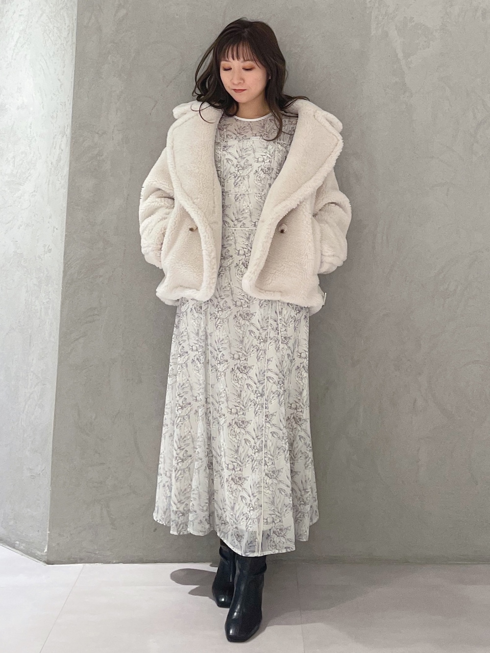 ホワイト系のワンピース、ホワイト系のその他アウター、ブラック系のブーツを着用したレディースの秋コーディネートの1枚目の写真