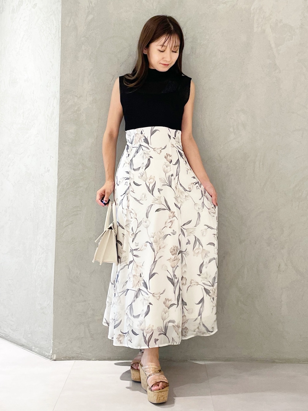 ブラック系のワンピース、ブラウン系のサンダル、ベージュ系のショルダーバッグを着用したレディースの夏コーディネートの1枚目の写真