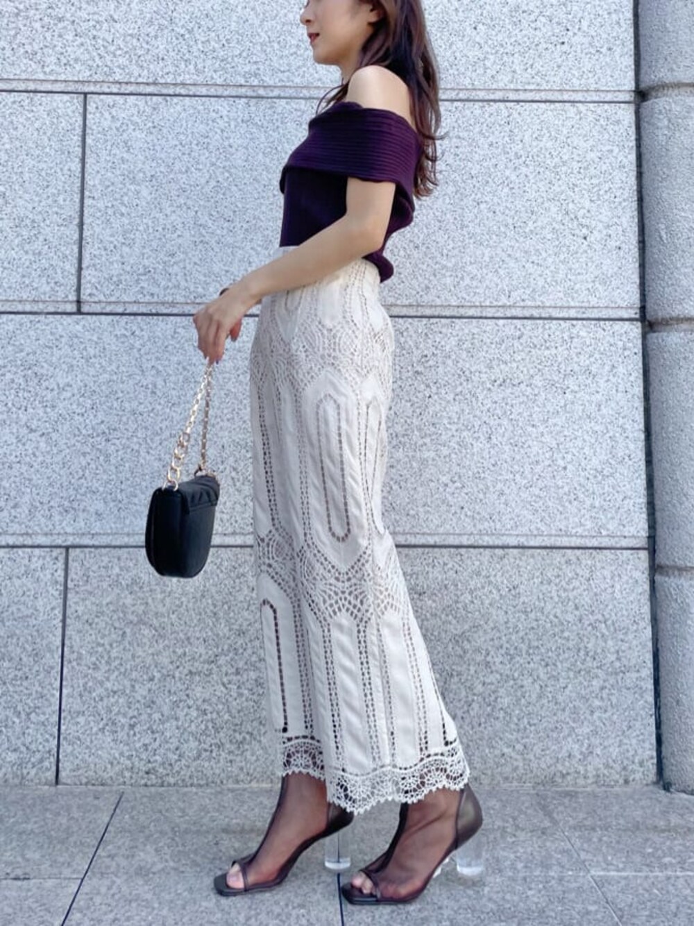 ホワイト系のスカート、ゴールド系のハンドバッグ、ブラック系のその他シューズを着用したレディースの夏コーディネートの1枚目の写真