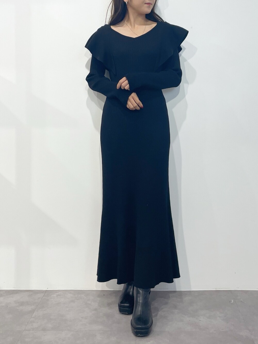 ブラック系のワンピース、ブラック系のブーツを着用したレディースの冬コーディネートの1枚目の写真