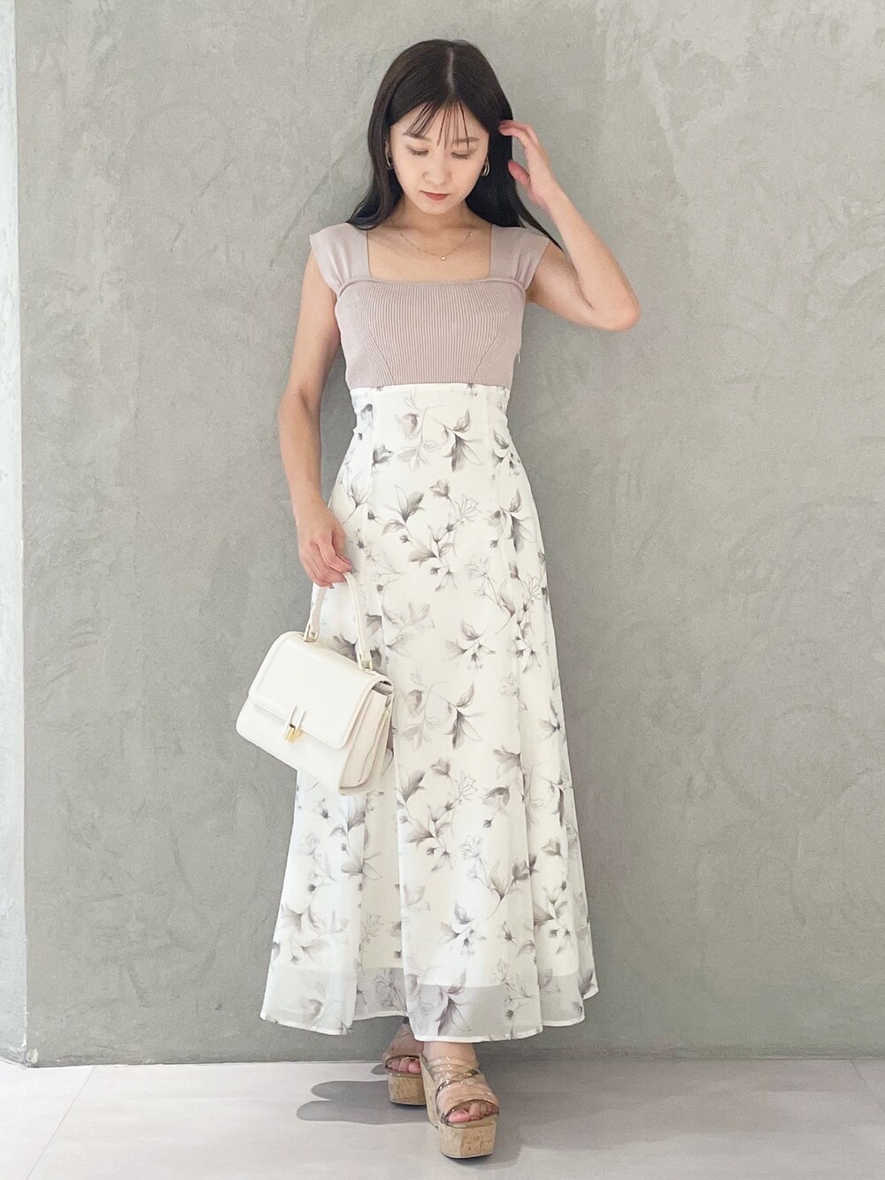ベージュ系のワンピース、ブラウン系のサンダル、ホワイト系のショルダーバッグを着用したレディースの夏コーディネートの1枚目の写真