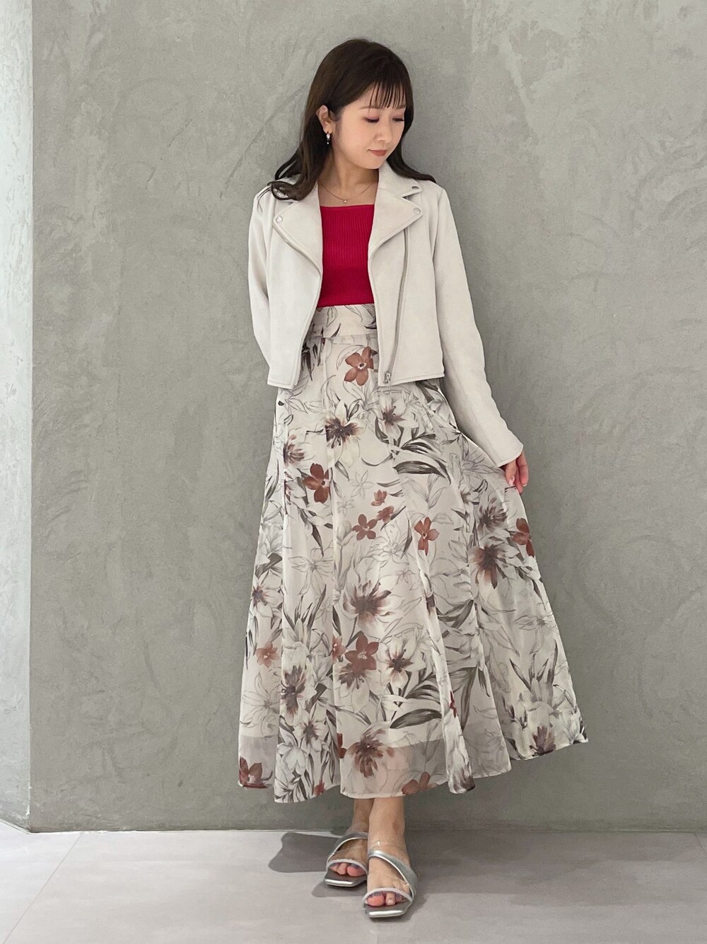 ピンク系のスカート、ピンク系のライダースジャケット、レッド系のニット/セーターを着用したレディースの春コーディネートの1枚目の写真