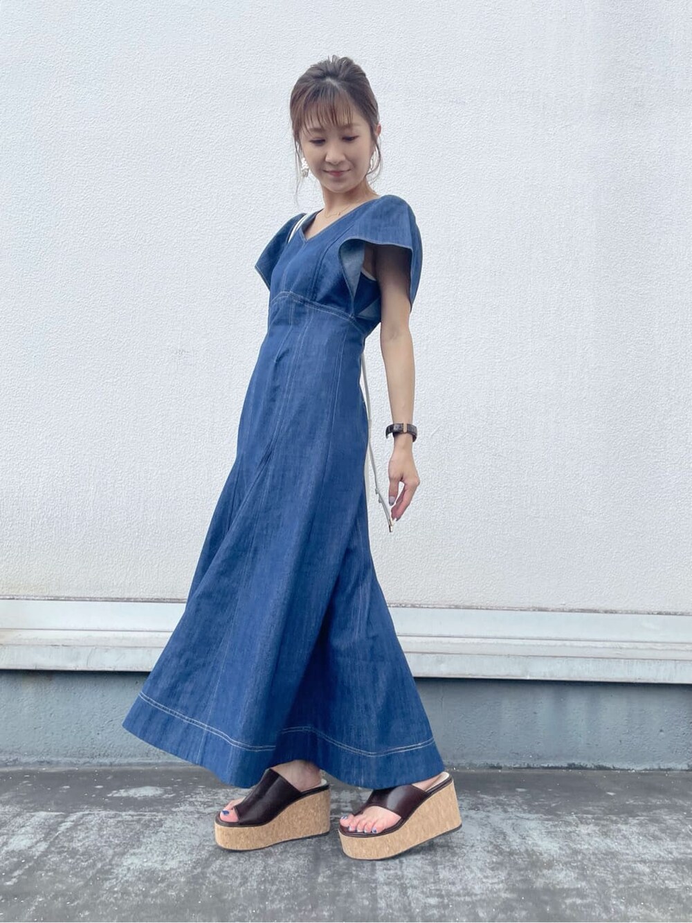 ブルー系のワンピース、ブラウン系のサンダル、ホワイト系のハンドバッグを着用したレディースの夏コーディネートの1枚目の写真