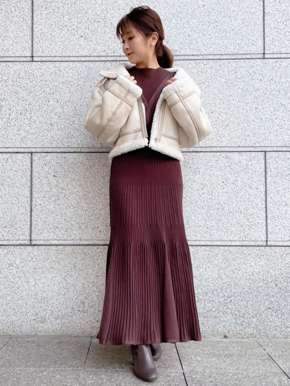 ホワイト系のテーラードジャケット、ブラウン系のワンピースを着用したレディースの秋コーディネートの1枚目の写真