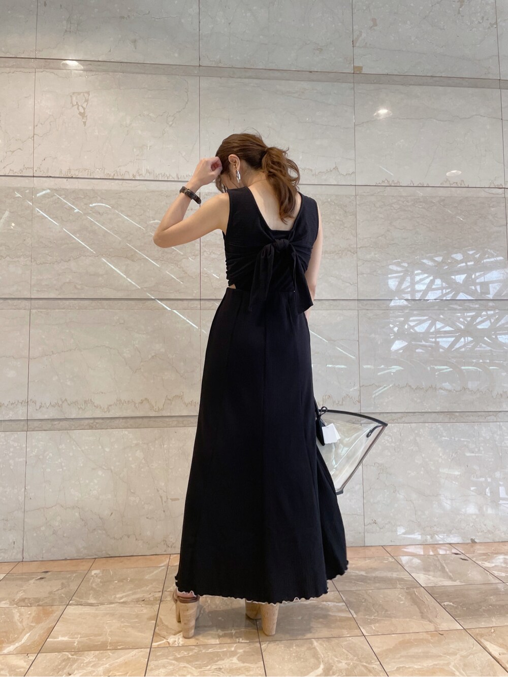 ブラック系のトートバッグ、ベージュ系のサンダルを着用したレディースの夏コーディネートの1枚目の写真