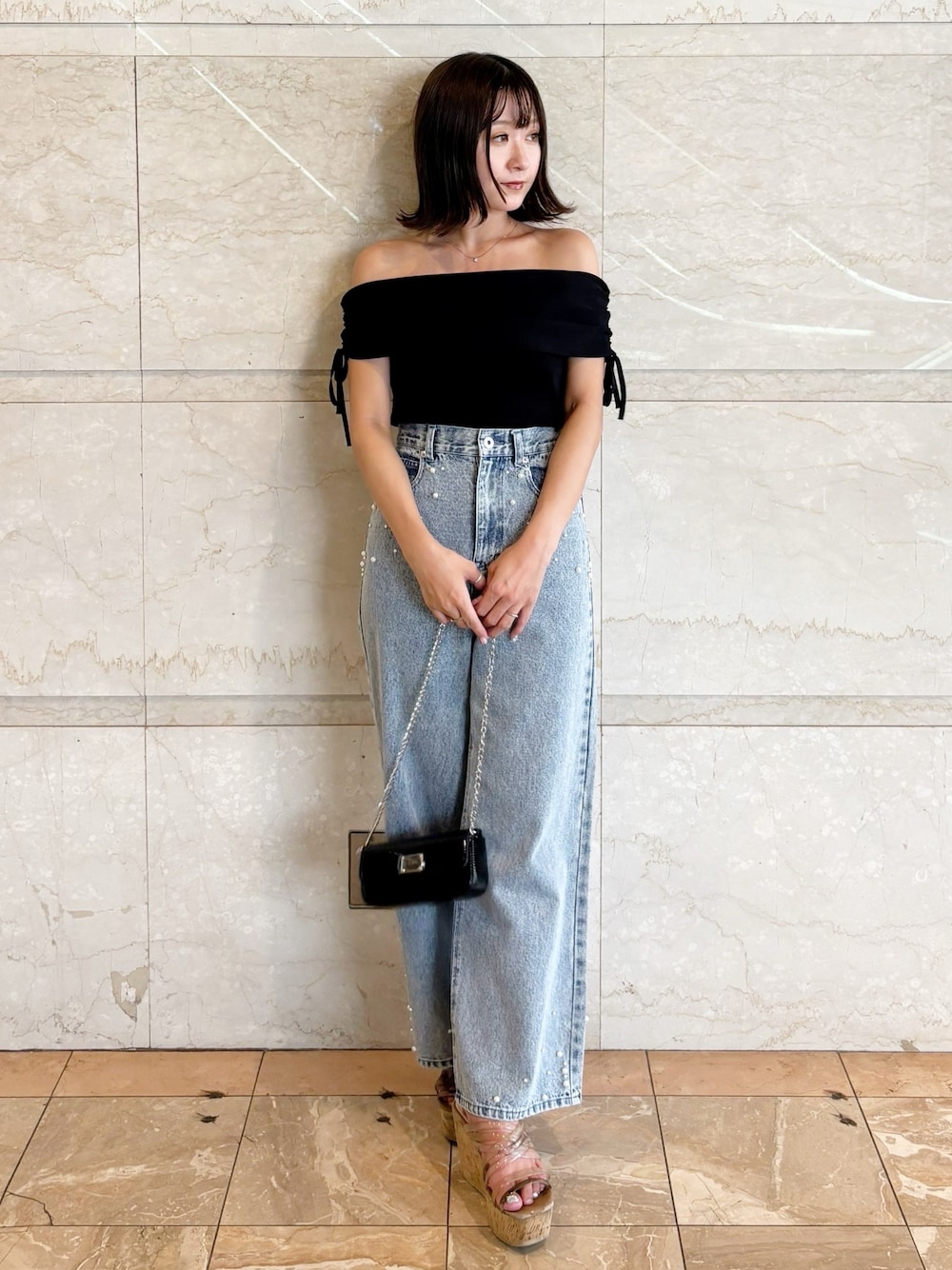 ブラック系のボディバッグ/ウエストポーチ、ブラック系のニット/セーター、ブルー系のデニムパンツを着用したレディースの夏コーディネートの1枚目の写真