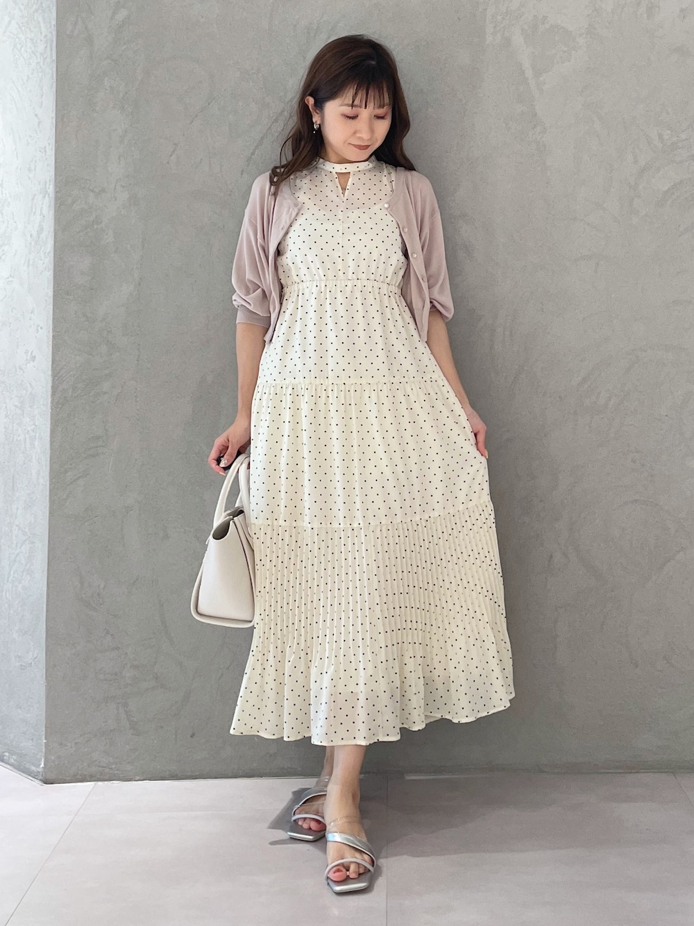 ベージュ系のワンピース、ホワイト系のトートバッグ、シルバー系のサンダルを着用したレディースの夏コーディネートの1枚目の写真