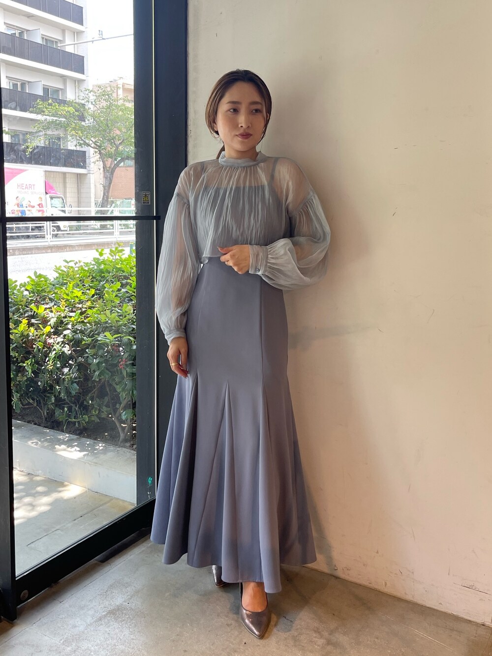 シルバー系のパンプス、ブルー系のドレスを着用したレディースの秋コーディネートの1枚目の写真