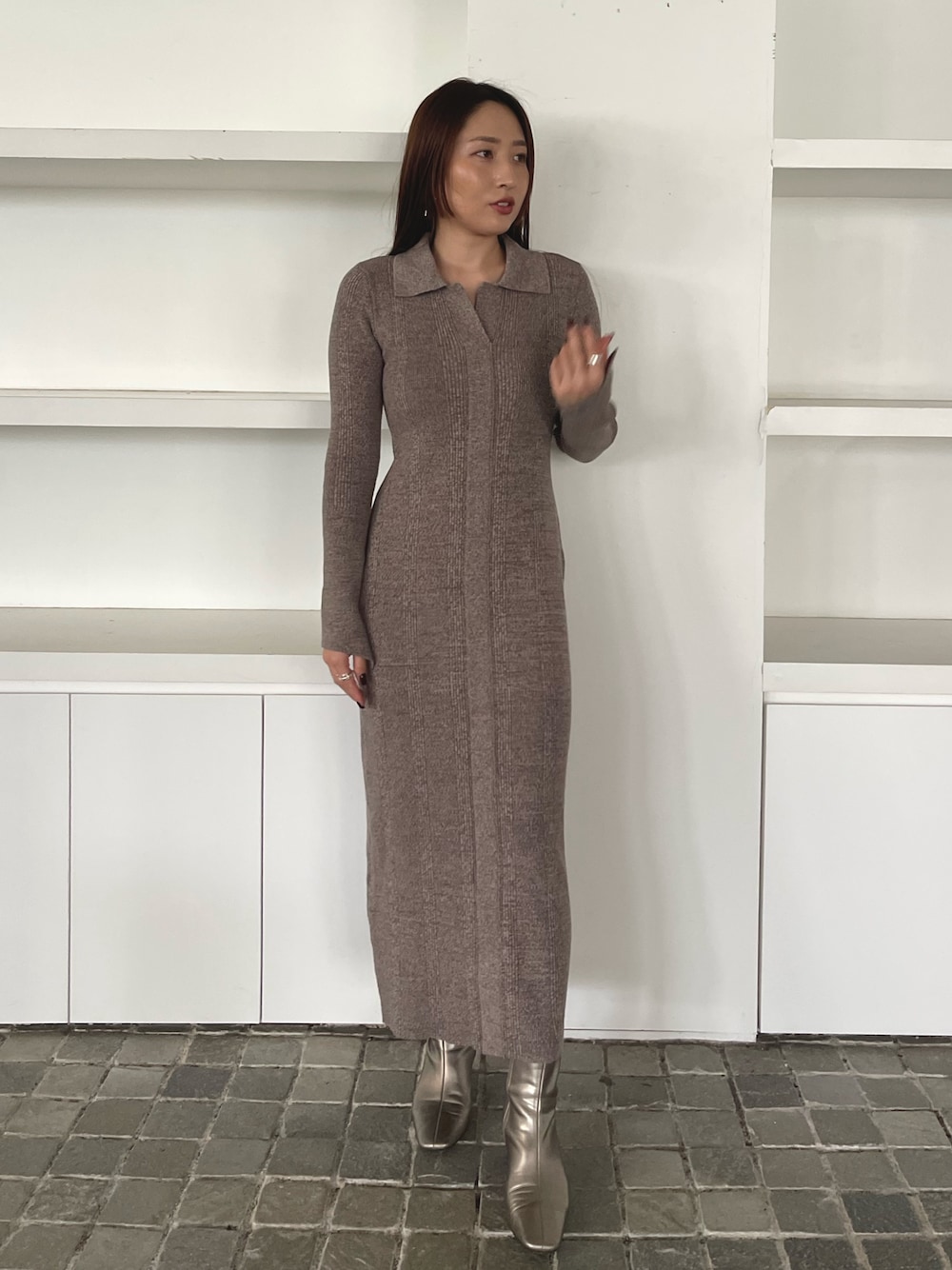 グレー系のワンピース、シルバー系のブーツを着用したレディースの冬コーディネートの1枚目の写真