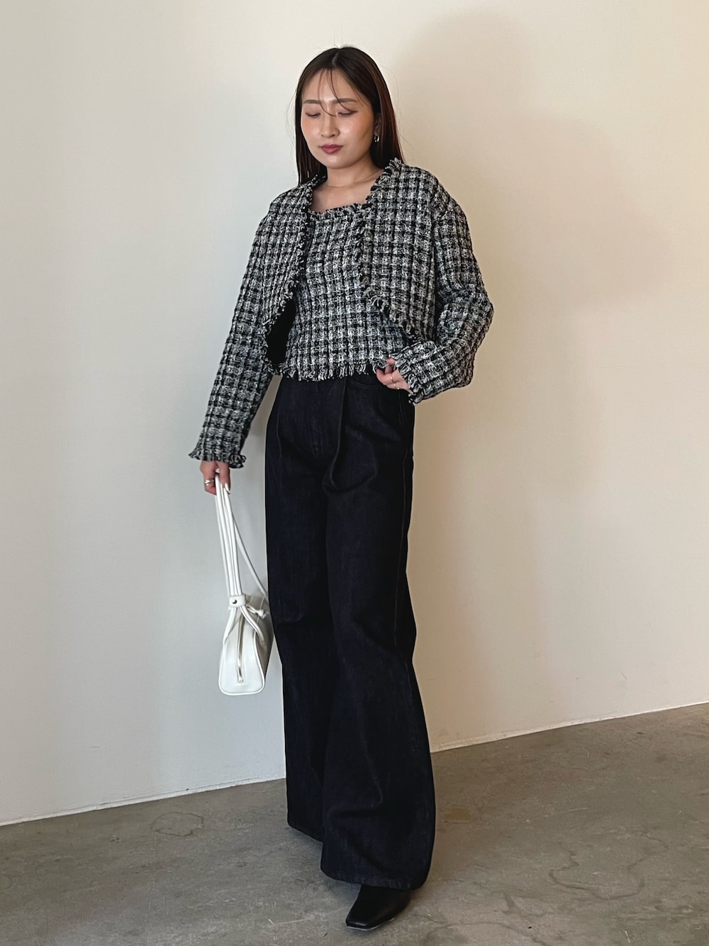 ホワイト系のショルダーバッグ、ブラック系のキャミソール、ブラック系のテーラードジャケットを着用したレディースの秋コーディネートの1枚目の写真