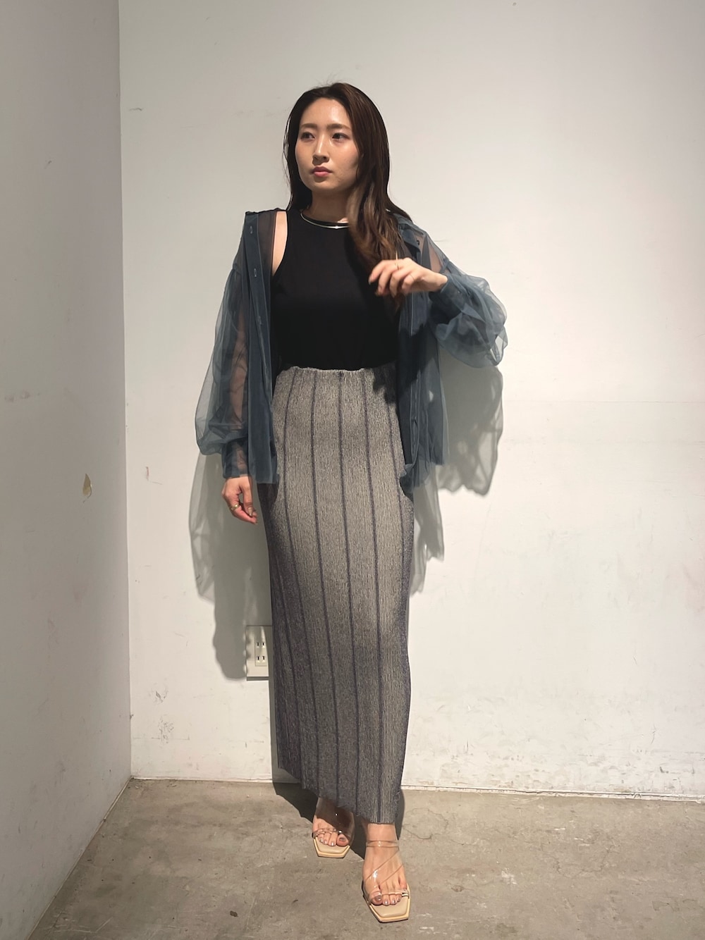 ブルー系のシャツ/ブラウス、グレー系のスカート、ブラック系のTシャツ/カットソーを着用したレディースの春コーディネートの1枚目の写真