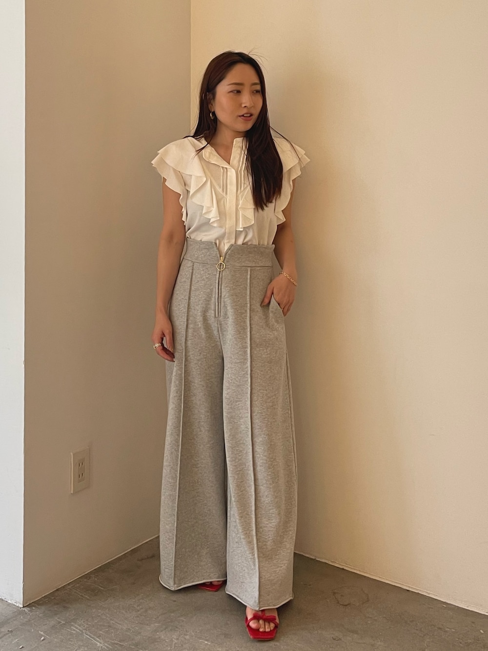 レッド系のサンダル、ホワイト系のシャツ/ブラウス、グレー系のスウェットパンツを着用したレディースの春コーディネートの1枚目の写真