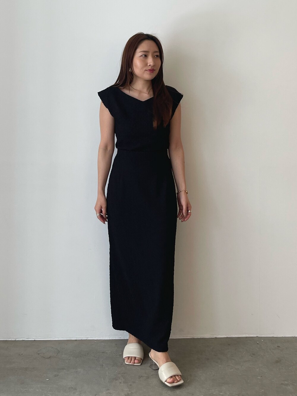 ホワイト系のサンダル、ブラック系のTシャツ/カットソー、ブラック系のスカートを着用したレディースの春コーディネートの1枚目の写真