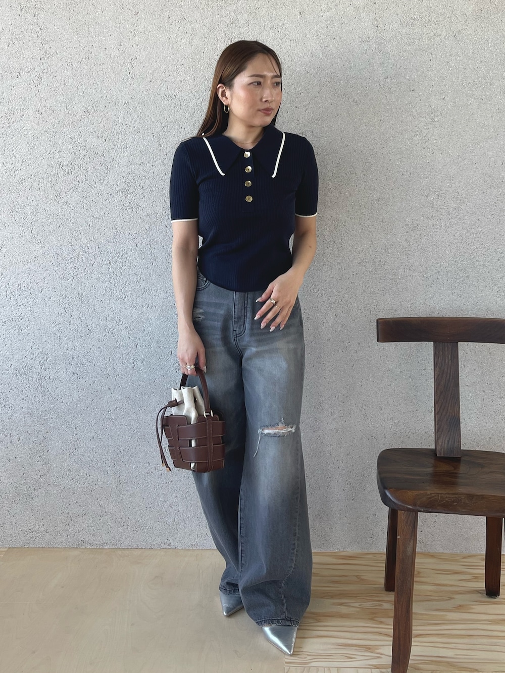 グレー系のデニムパンツ、シルバー系のパンプス、ブルー系のニット/セーターを着用したレディースの春コーディネートの1枚目の写真