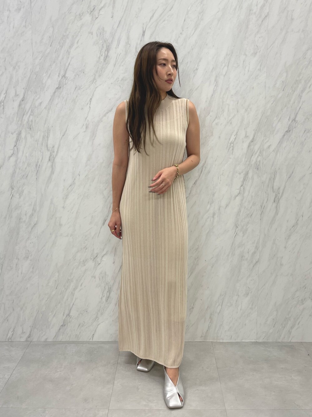 シルバー系のパンプス、ホワイト系のワンピースを着用したレディースの春コーディネートの1枚目の写真