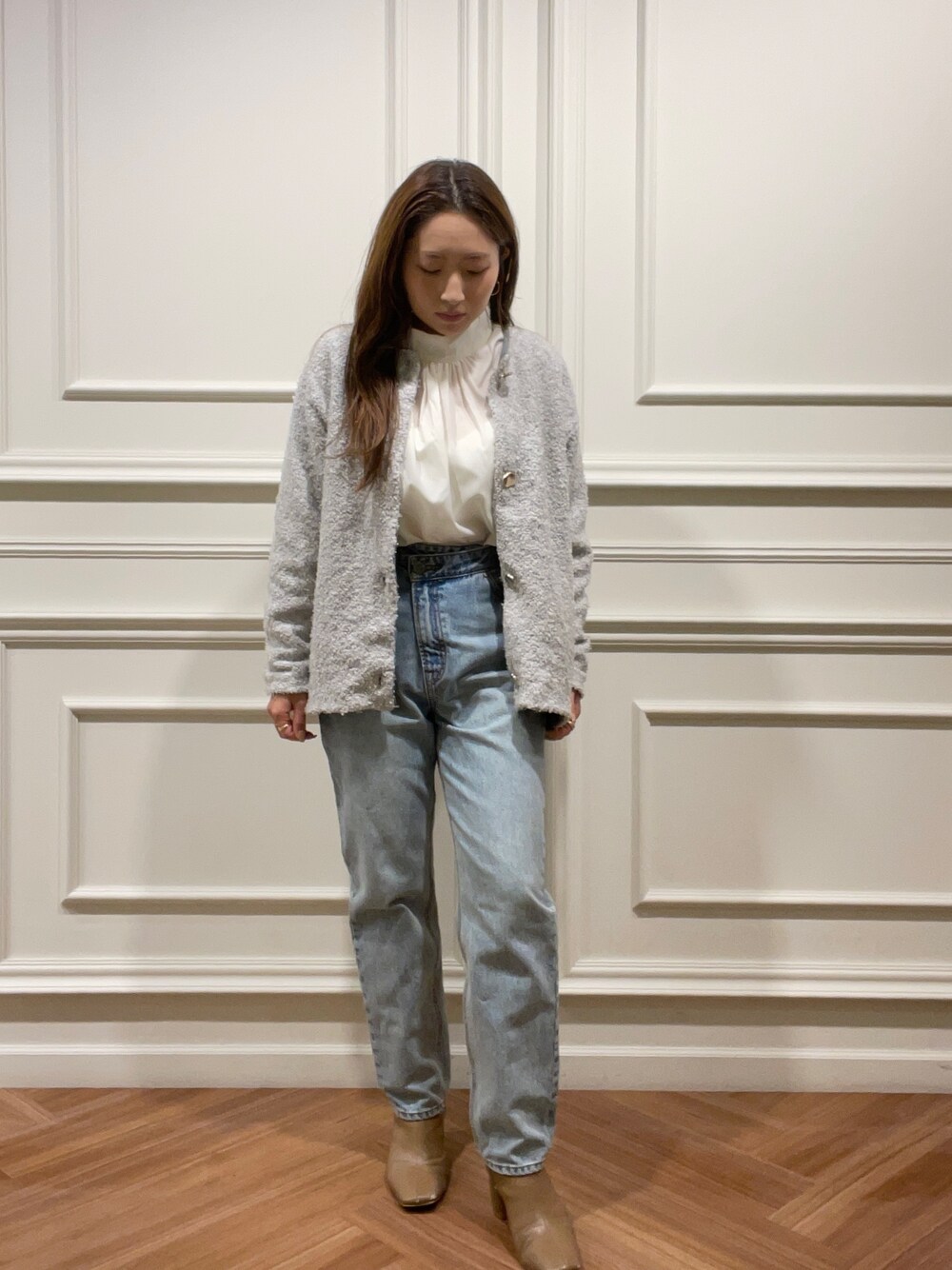 ベージュ系のブーツ、グレー系のカーディガン/ボレロ、ブルー系のデニムパンツを着用したレディースの秋コーディネートの1枚目の写真