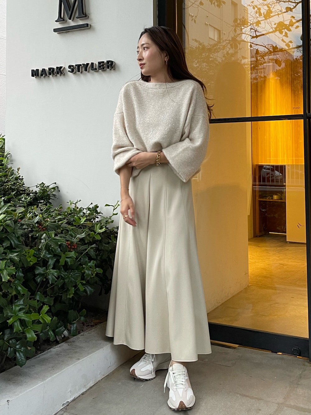 ホワイト系のカーディガン/ボレロ、ホワイト系のスカートを着用したレディースの秋コーディネートの1枚目の写真