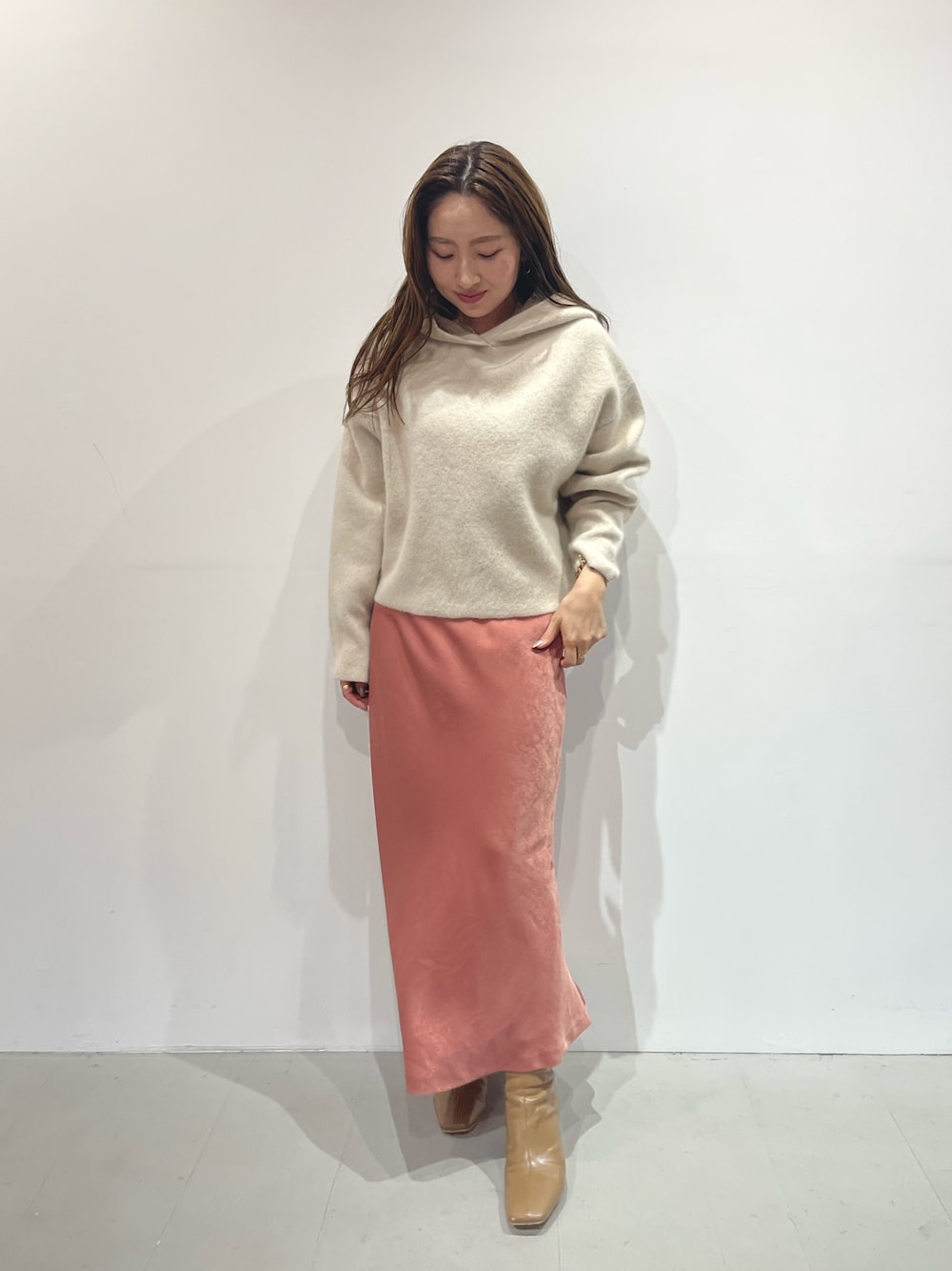 ピンク系のスカート、ベージュ系のブーツ、ホワイト系のパーカーを着用したレディースの夏コーディネートの1枚目の写真