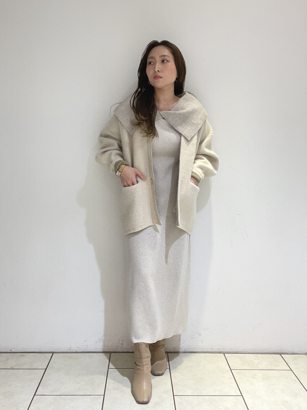 ホワイト系のワンピース、ホワイト系のカーディガン/ボレロ、ベージュ系のブーツを着用したレディースの冬コーディネートの1枚目の写真