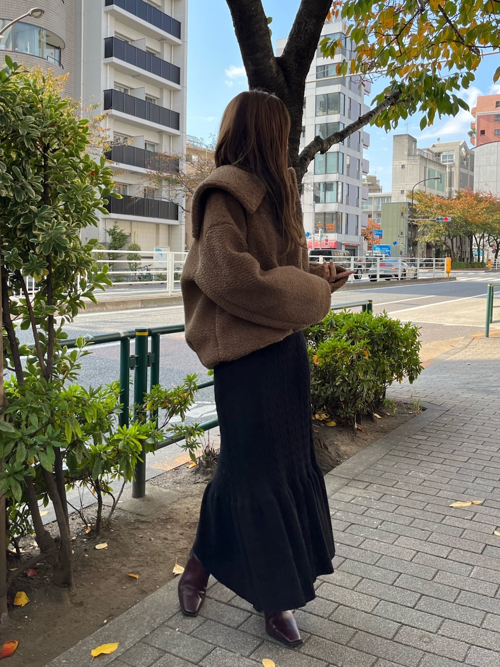 ブラウン系のブルゾン、レッド系のブーツ、ブラック系のワンピースを着用したレディースの秋コーディネートの1枚目の写真