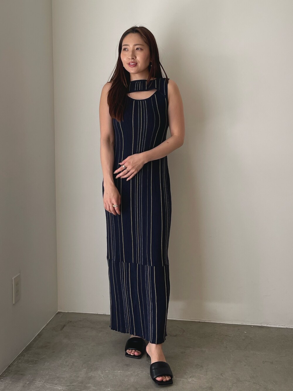 ブラック系のサンダル、ブルー系のワンピースを着用したレディースの春コーディネートの1枚目の写真