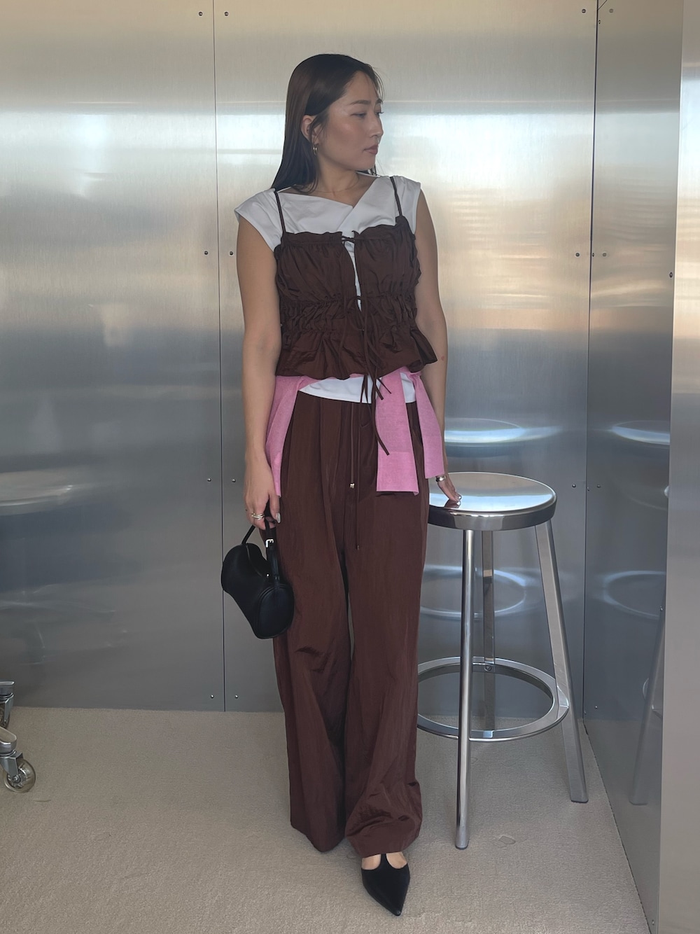 ブラック系のパンプス、ホワイト系のTシャツ/カットソー、ブラウン系のキャミソールを着用したレディースの春コーディネートの1枚目の写真