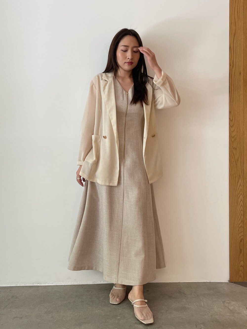 ベージュ系のワンピース、ホワイト系のサンダル、ホワイト系のテーラードジャケットを着用したレディースの夏コーディネートの1枚目の写真