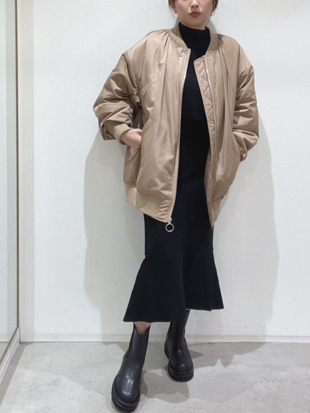 ブラック系のブーツ、ブラック系のニット/セーター、ブラック系のスカートを着用したレディースの秋コーディネートの1枚目の写真