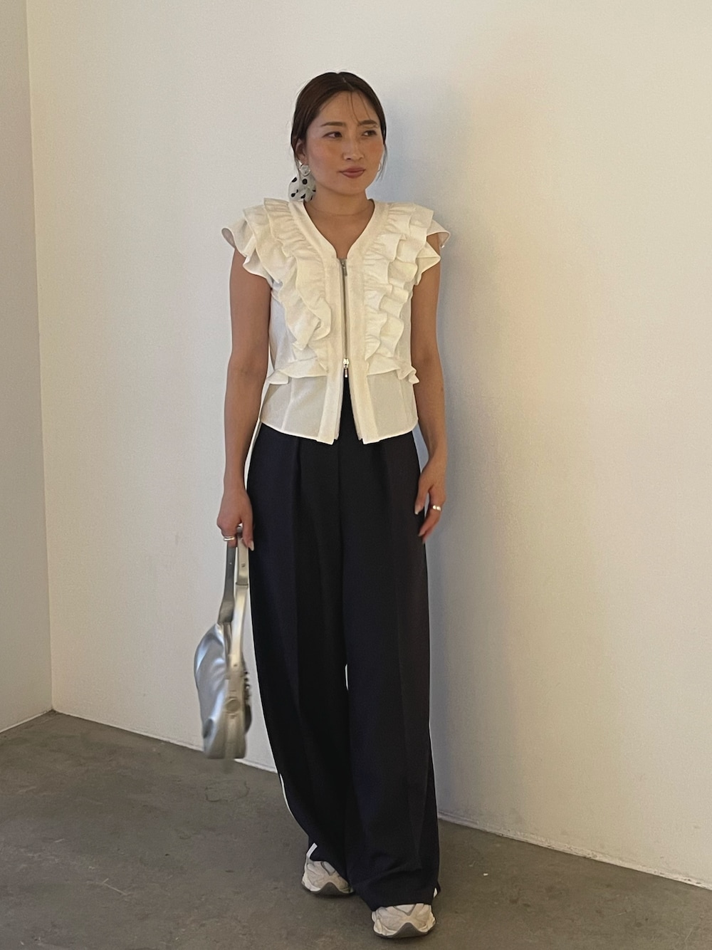 シルバー系のハンドバッグ、ホワイト系のシャツ/ブラウス、グレー系のその他パンツを着用したレディースの春コーディネートの1枚目の写真